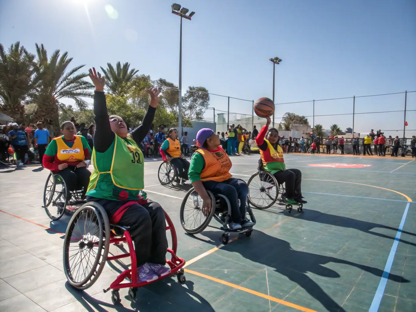 Image d’un entraîneur encourageant un jeune joueur en fauteuil roulant lors d’un atelier de sport adapté, mettant en avant l’accompagnement personnalisé et l’accessibilité des activités.